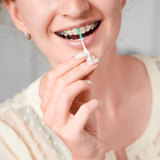 young-woman-with-braces-teeth-using-elastic-cleaning-toothpick.jpg